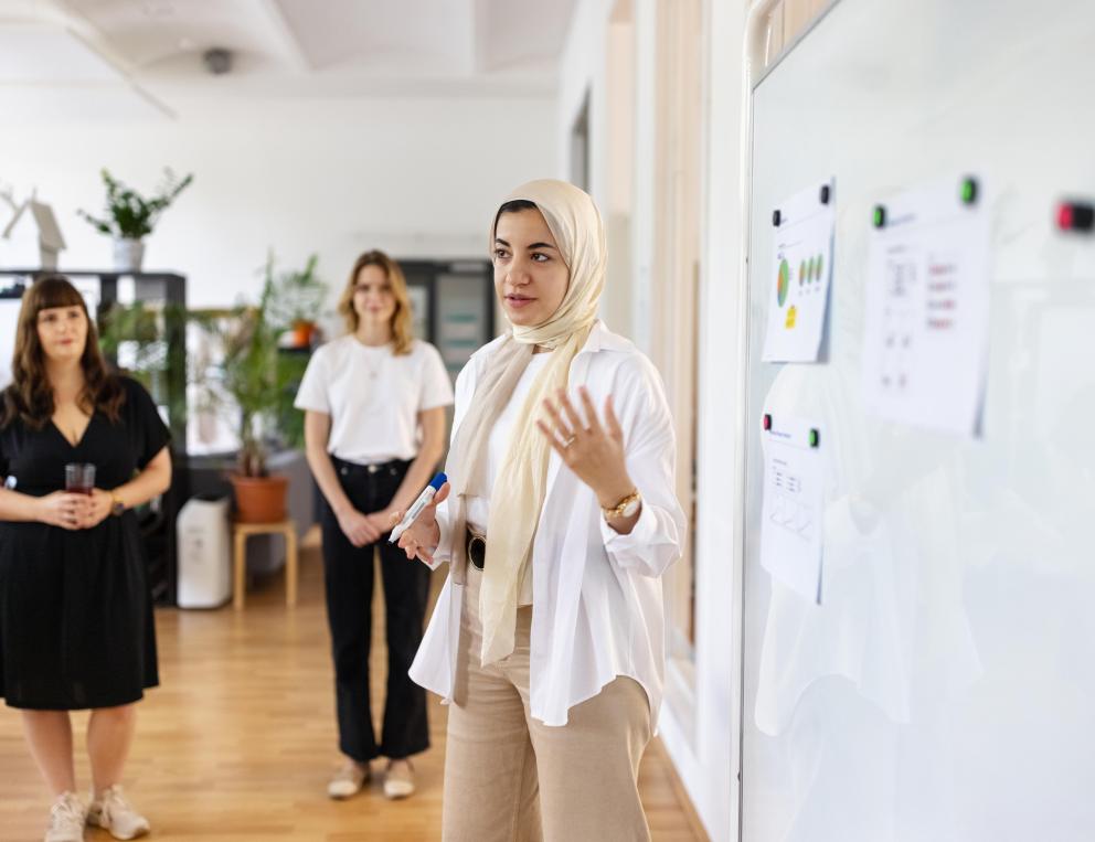 A female faculty member teaching at a white board.